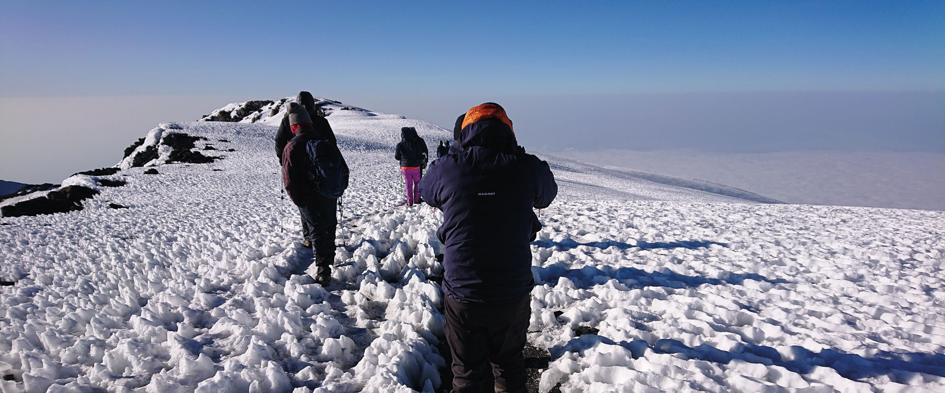 Close-up view of pristine, brilliant white snowpack and ice formations along the trail just below the summit.