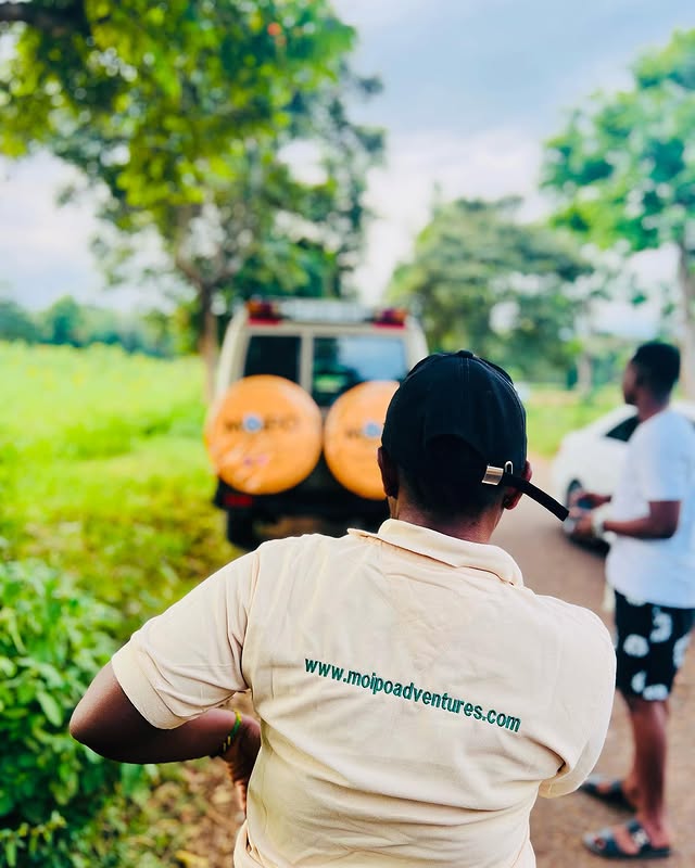 Rear view of a staff member wearing a Moipo t-shirt displaying the website link, standing next to a safari cruiser wrapped in Moipo branding and logos. Instagram post